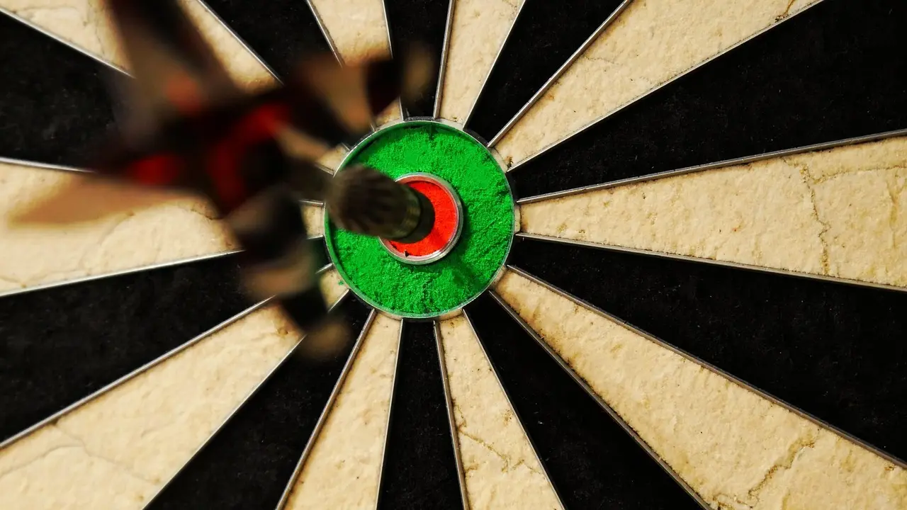En dartpil i bullseye på et dartbræt