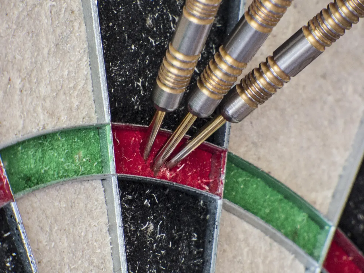Tre dartpile i en dartskive